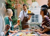 Staff member serving drinks to customers in a pub garden