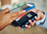 Person using a card machine to accept a mobile payment