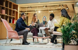 Company team sitting together in an open-plan office space.