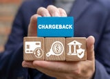 Person holding a block that reads 'chargeback'