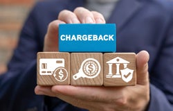 Person holding a block that reads 'chargeback'