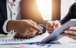 Two people looking at an investment pitch on an ipad screen