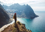 Man standing on cliff looking out to sea
