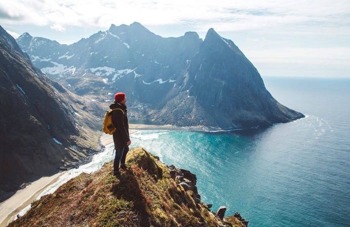 Man standing on cliff looking out to sea