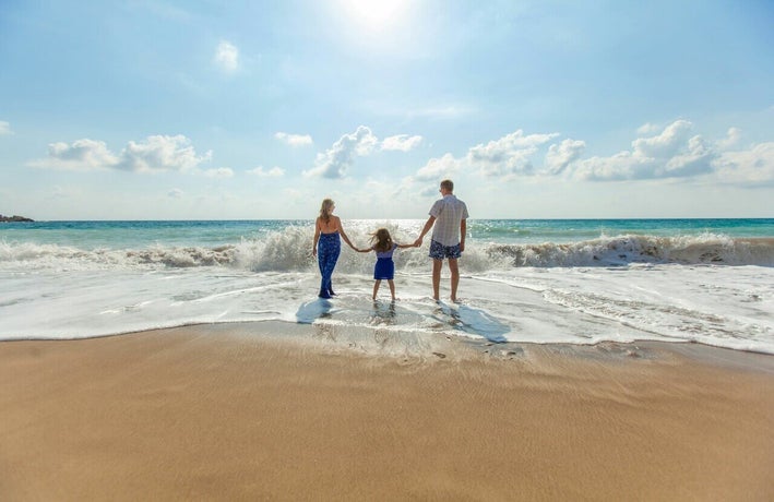 Family paddling in the sea at the beach