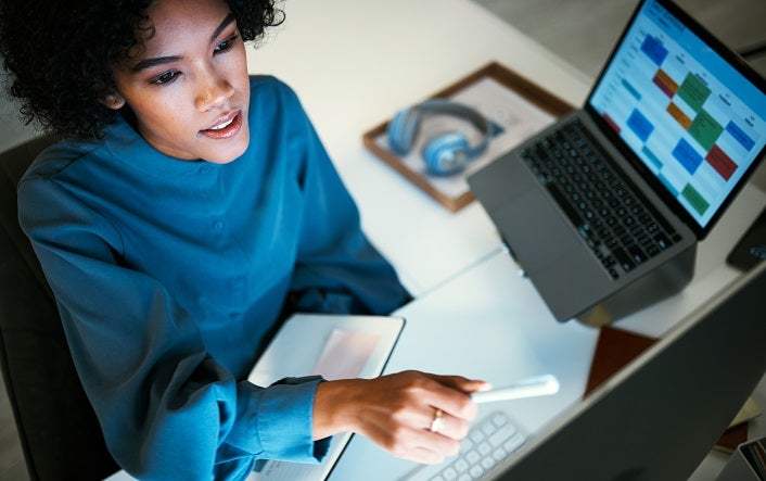 Woman with computer, notebook and checking schedule, agenda and reminder for office administration. Online calendar, diary and girl at desk planning spreadsheet for time management with high angle