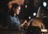 Woman, office and table on internet at night for overtime, working or digital marketing with technology. Professional businesswoman, late and tech for web, email or communication on app in workplace.