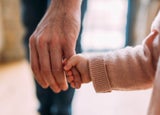 Baby holding a man's finger