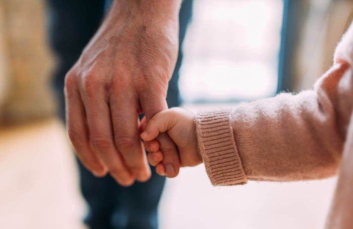 Baby holding a man's finger
