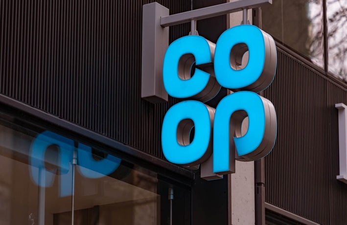 Sign of the co-op hanging outside a high street store.