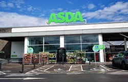 A shot of the outside of an Asda store with its logo displayed prominently on top of the building.