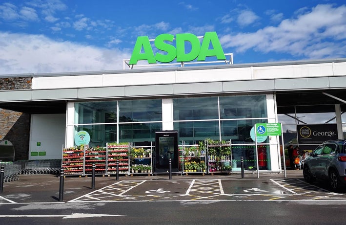 A shot of the outside of an Asda store with its logo displayed prominently on top of the building.