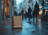 A lone brown paper bag sitting on the wet ground of a busy high street on a rainy day.