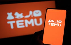 A smartphone device displaying the Temu logo against an orange background. The same also appears on a computer screen behind the phone.