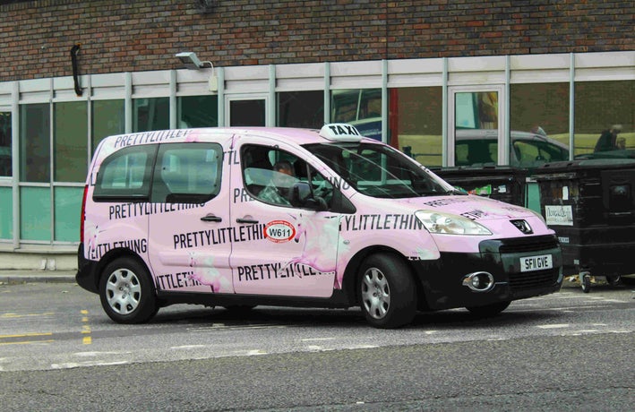 Pink PrettyLittleThing van on road